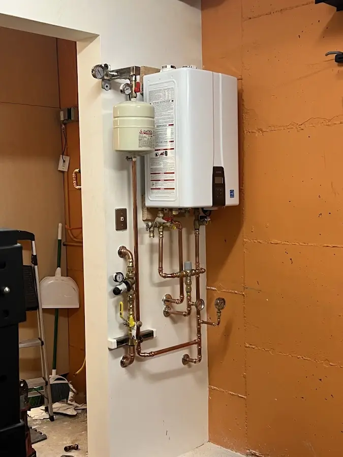 Plumbing technician inspecting water heater connections in South Lakes